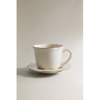 Фарфоровая чашка и блюдце с деталями на краю