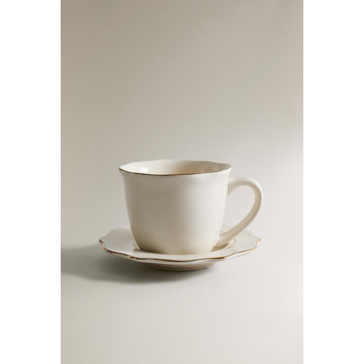 Фарфоровая чашка и блюдце с деталями на краю