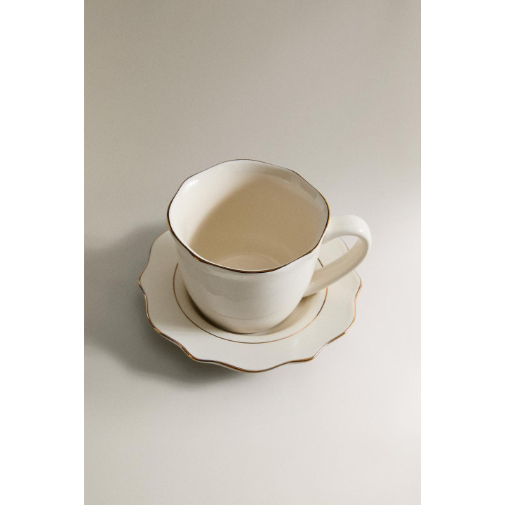 Фарфоровая чашка и блюдце с деталями на краю