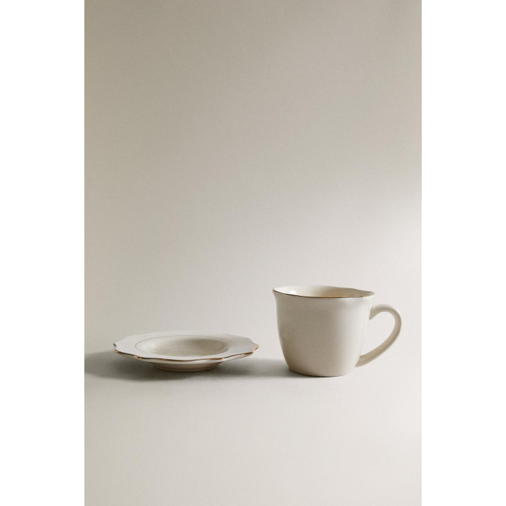 Фарфоровая чашка и блюдце с деталями на краю