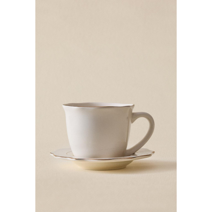 Фарфоровая чашка и блюдце с деталями на краю