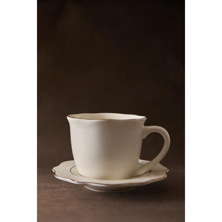 Фарфоровая чашка и блюдце с деталями на краю