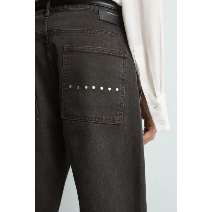 Джинсы с расклешенными штанинами и восковым покрытием