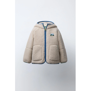 Полушубок из аккуратноподделанного меха с капюшоном и контрастной отделкой