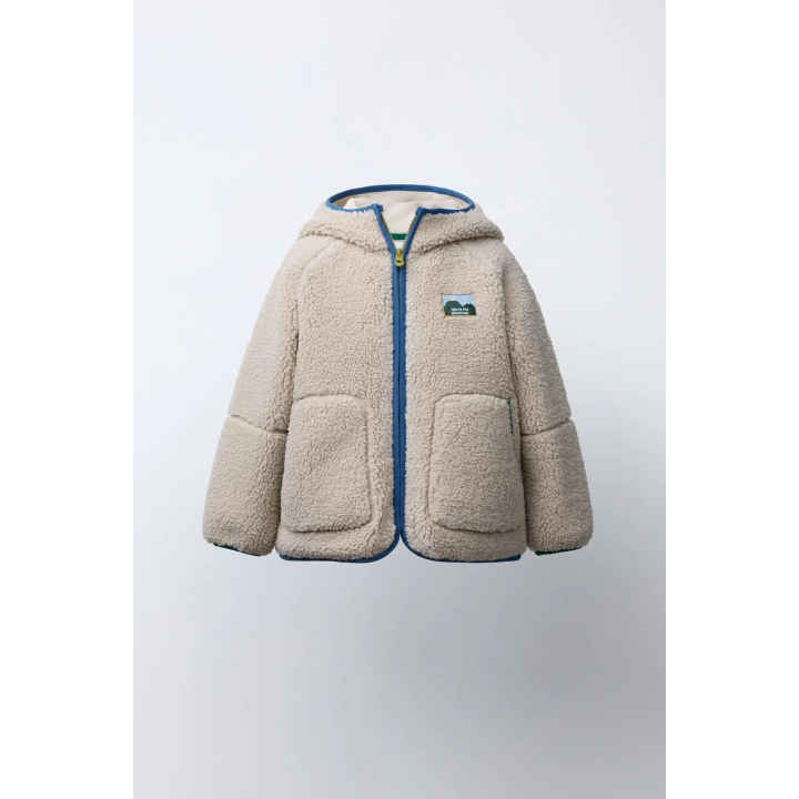 Полушубок из аккуратноподделанного меха с капюшоном и контрастной отделкой