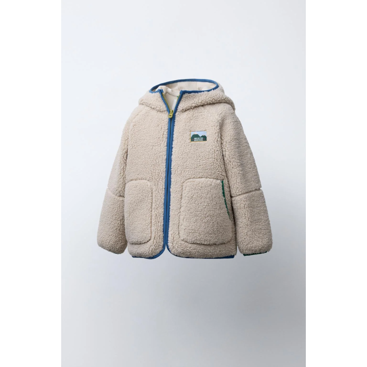 Полушубок из аккуратноподделанного меха с капюшоном и контрастной отделкой