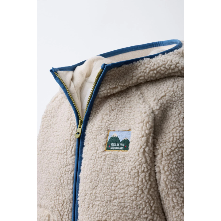 Полушубок из аккуратноподделанного меха с капюшоном и контрастной отделкой