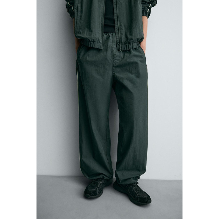 БРЮКИ-ДЖОГГЕРЫ ИЗ ВЫСОКОТЕХНОЛОГИЧНОЙ ТКАНИ С КОНТРАСТНЫМИ ДЕТАЛЯМИ