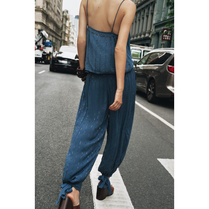 Брюки с бисером и завязками на подворотах