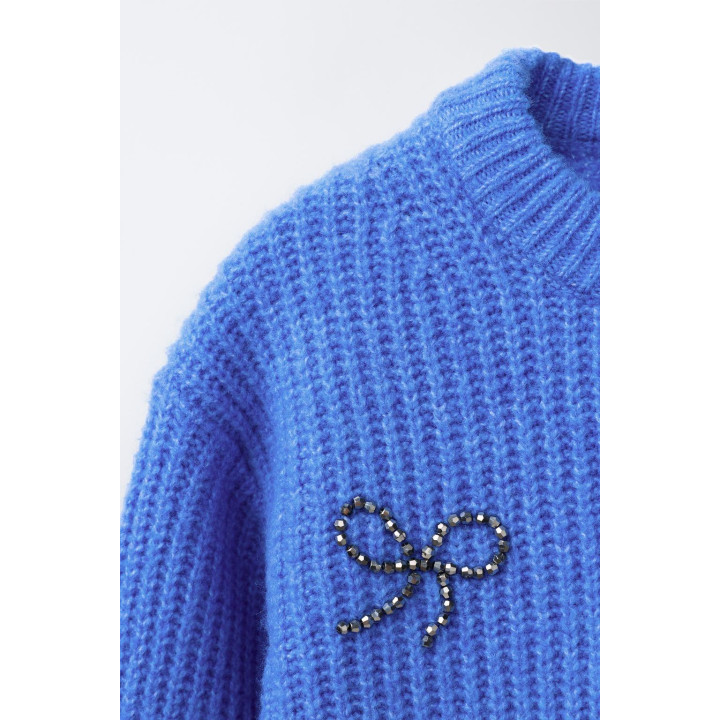 ТРИКОТАЖНЫЙ ДЖЕМПЕР С БУСИНАМИ, БАНТАМИ И БЛЕСТКАМИ